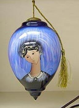 Blue Madonna glass ornament by artist P Buckley Moss features the lovely Madonna in colors of light and dark blue blended colors. Suitable for hanging on the tree or displayed elegantly all year round.