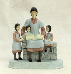 Reading to My Girls figurine by P Buckley Moss. Mother reading to three small girls. Colors are soft blue, rose and cream with gray shades in the stone bench.