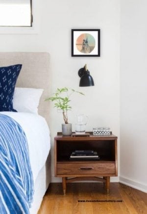 How do you hang art? Shown above a bedside night table.