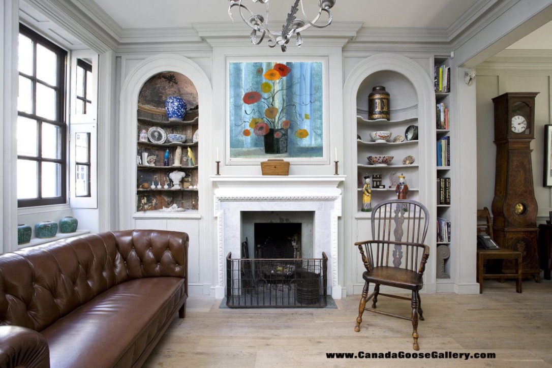 Traditional living room with a brown leather sofa, white fireplace with built-in shelves, and a bright floral artwork centered above the mantel.