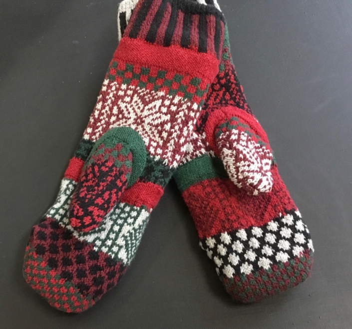 Poinsettia Solmate Mittens is a combination of dark reds, white, green and black. Poinsettia Solmate Mittens is a combination of dark reds, white, green and black.