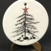 Purrfect Christmas porcelain ornament by P Buckley Moss. White background with black limbs on the tree and black cats under the tree. A few colored ornaments on the tree.
